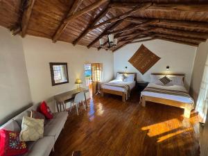 ein Wohnzimmer mit zwei Betten und einer Couch in der Unterkunft Urquillos Wasi - Andean Cottage in Urubamba