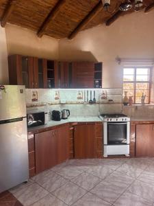 eine Küche mit Herd und Kühlschrank in der Unterkunft Urquillos Wasi - Andean Cottage in Urubamba + 19 Fotos
