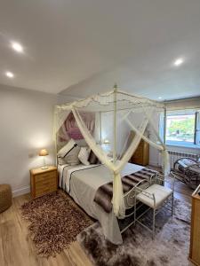 a bedroom with a canopy bed and a chair at El Ansar de Daniela , Casa Rural in Treceño