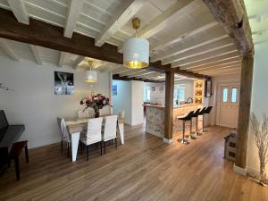 a dining room and living room with a table and chairs at El Ansar de Daniela , Casa Rural in Treceño