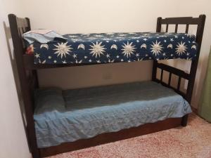 a bunk bed with a blue and white blanket on it at La Morada de sus Sueños in Bialet Massé