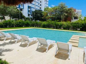 a group of chairs sitting next to a swimming pool at Lovely 2 bedroom 2 bathroom condo in Cancún +8 photos