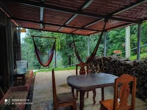 a patio with a table and chairs and a hammock at Cabañas San José del Pacífico in San Mateo Río Hondo