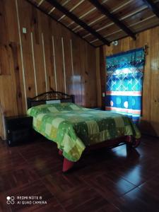 a bedroom with a bed in a wooden room at Cabañas San José del Pacífico in San Mateo Río Hondo