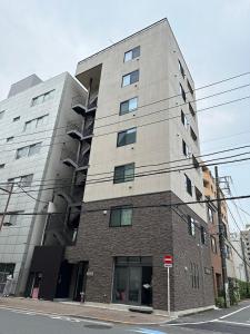ein hohes Gebäude an der Ecke einer Straße in der Unterkunft SOLASIA residence 北上野401 in Tokio
