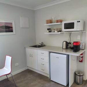 a kitchen with a counter with a microwave and a sink at Fairburn Hideaway in Cambridge