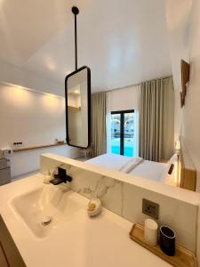 ein Bad mit einem Waschbecken und ein Bett mit einem Spiegel in der Unterkunft Diving Addiction Resort in Panglao