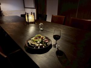 a table with a plate of food and a glass of wine at Vineyard Vista ENZAN in Koshu
