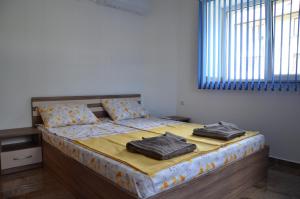 a bedroom with a bed with two pillows on it at Стаи за гости Мартинови in Zlatograd