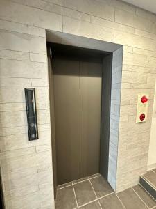 eine Fahrstuhltür in einem Gebäude mit roter Beleuchtung in der Unterkunft SOLASIA residence 北上野401 in Tokio