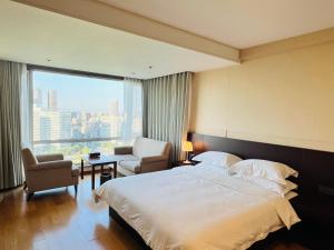 a hotel room with a large bed and a chair at Pumpkin Hotel in Beijing
