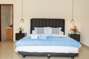 Un dormitorio con una cama grande con dos mesitas de noche. en Villa Azula Bali, en Canggu