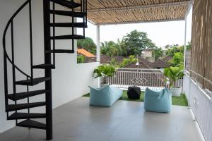 Un balcón con escalera de caracol y almohadas azules. en Villa Azula Bali, en Canggu