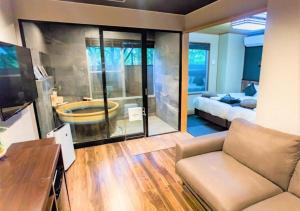un soggiorno con un divano e una camera da letto di LiVEMAX RESORT Hakone Ashinoko a Hakone