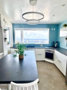 a kitchen with a table with a potted plant on it at Villa Téloam- Charmante villa avec piscine et vue mer in Schœlcher