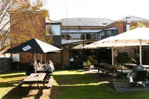 a group of people sitting at tables with umbrellas at Avon Valley Inn Hotel in Gloucester +9 photos