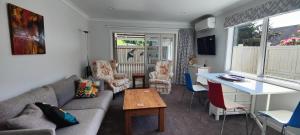 a living room with a couch and a table at Fairburn Hideaway in Cambridge