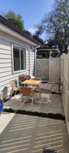 a patio with a table and chairs and a fence at Fairburn Hideaway in Cambridge