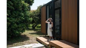 a woman standing outside of a tiny house at Tsinghua 1 Tiny Home by Tiny Away in Hsien-tzu-liao