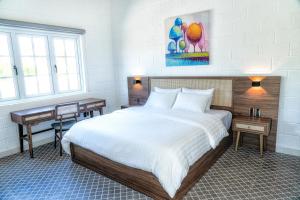 a bedroom with a large bed and a desk at Perolas Villas Resort - Ke Ga Bay in Phan Thiet