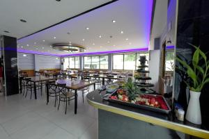 a restaurant with tables and chairs and a buffet at Valentine Hotel Angeles City managed by Cocotel in Angeles