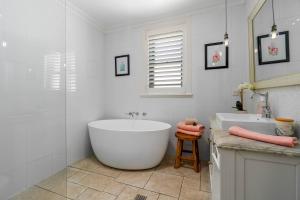 un bagno con una grande vasca e un lavandino di Clinton Charm - Stunning Heritage Home near CBD a Orange