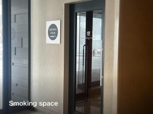 a sliding glass door with a smoking space sign on it at Kansai Airport Washington Hotel in Izumi-Sano