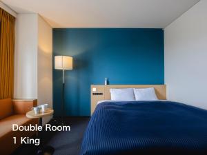 a blue bedroom with a bed and a blue wall at Kansai Airport Washington Hotel in Izumi-Sano