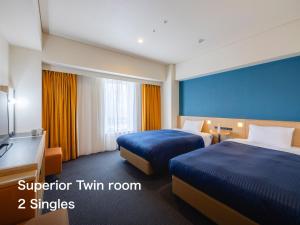a hotel room with two beds and a television at Kansai Airport Washington Hotel in Izumi-Sano