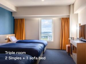 a hotel room with a bed and a window at Kansai Airport Washington Hotel in Izumi-Sano