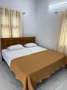 a bedroom with a large bed with two pillows at Joseph's Residency Homestay in Podanūr