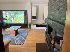 a living room with a brick fireplace with a table at Sepp's holiday apartment in Kapfenberg
