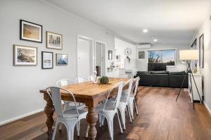 a dining room and living room with a wooden table and chairs at Valentine Sandcastles - Your Group Beach Escape! in Rye