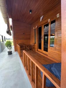 a large wooden deck with a table and bench at Lumbung Kembar Guest House, Nyanyi in Munggu
