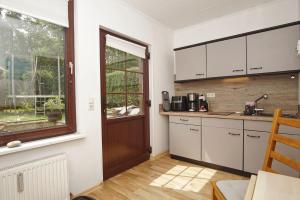 a kitchen with white cabinets and a window at Ferienhus Baabe bei Familie Vergien in Baabe +21 photos