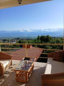 a patio with a table and chairs on a balcony at Omsi House in Telavi