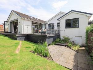 a house with a large deck with a lawn at Yonder Lea in Windermere