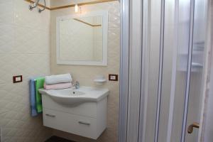 a white bathroom with a sink and a shower at Palazzo Primavera in Porto Cesareo +33 photos