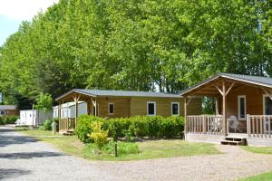 a couple of cottages with trees in the background at Camping La Loire Fleurie in Le Perrier +46 photos