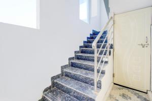 a stairway with blue stairs and a white door at SPOT ON Hari Hara Enterprises in Maula Ali