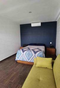 a bedroom with a bed and a couch at Casa de Campo Lake Shore Jocotepec in San Cristóbal Zapotitlán