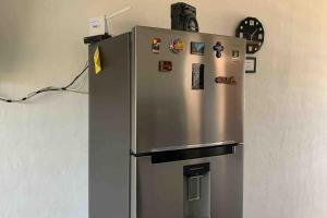 a stainless steel refrigerator with magnets and a clock at Casa de Campo Lake Shore Jocotepec in San Cristóbal Zapotitlán