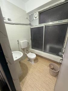 a bathroom with a toilet and a sink at Hotel Alohi Grand in Guwahati
