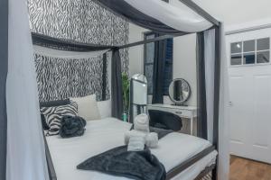 a bedroom with a canopy bed with a teddy bear on it at Highend Hideaway Duplex with 1 FREE Parking, backyard and deck, pool table, 2 Kings plus 2 Baths, Sleeps 10, 2 Floors! 20 PERCENT OFF in Hoboken