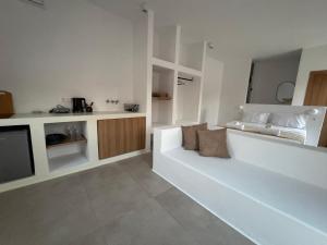 a white living room with a couch and a bed at Antiparos Gems in Agios Georgios