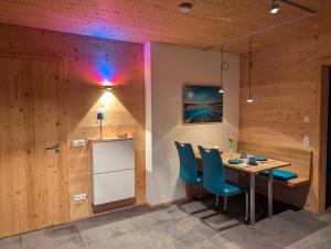 a dining room with a table and blue chairs at NaturWohnRaum - Urlaub im Holzhaus in Berg am Starnberger See