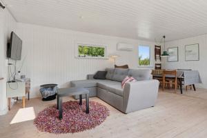 una sala de estar con un sofá y una mesa en Cozy House Near Beach And Town, en Frederikshavn
