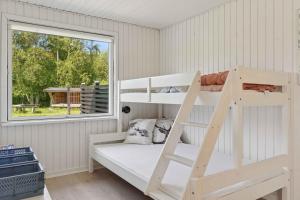 una litera en una habitación con ventana en Cozy House Near Beach And Town, en Frederikshavn
