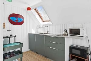 a kitchen with a sink and a microwave at Scenic Cottage Within Walking Distance To Beach in Nakskov