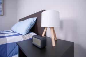 a lamp and a tv on a table next to a bed at Cozy Downtown London 1BR Gem in London